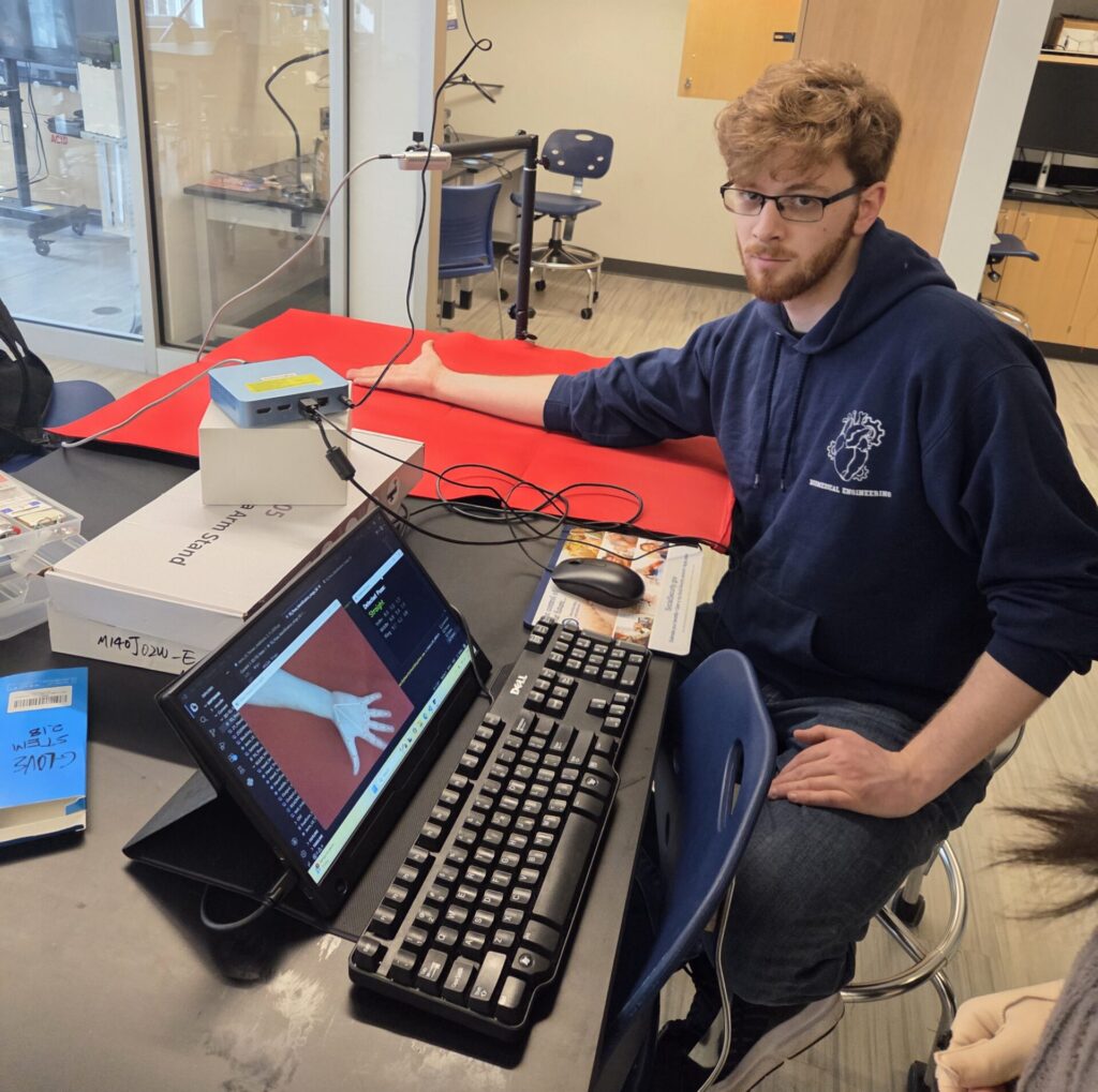 Jeremy testing the Tendon Gliding form recognition. His hand over a red pad under the realsense camera.