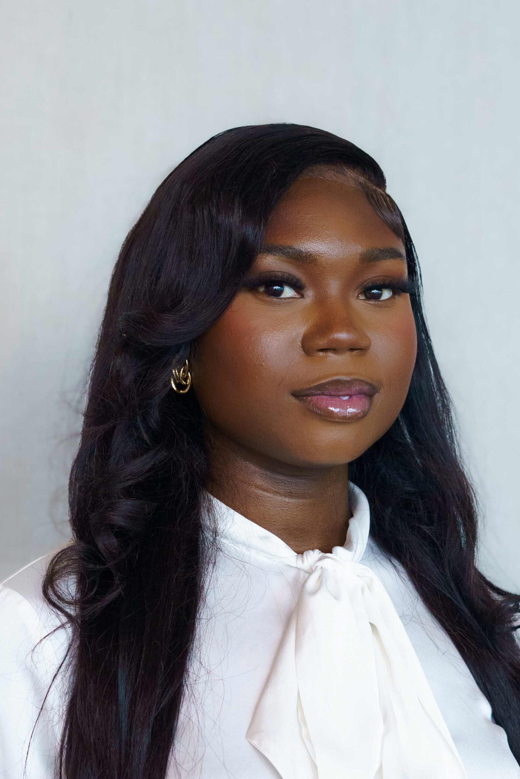 Gloria Afotey is posed for a headshot, wearing professional attire.
