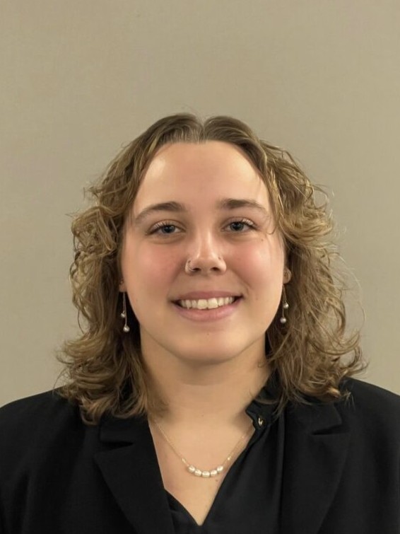 Emily Oberman is posed for a headshot, dressed in professional attire.