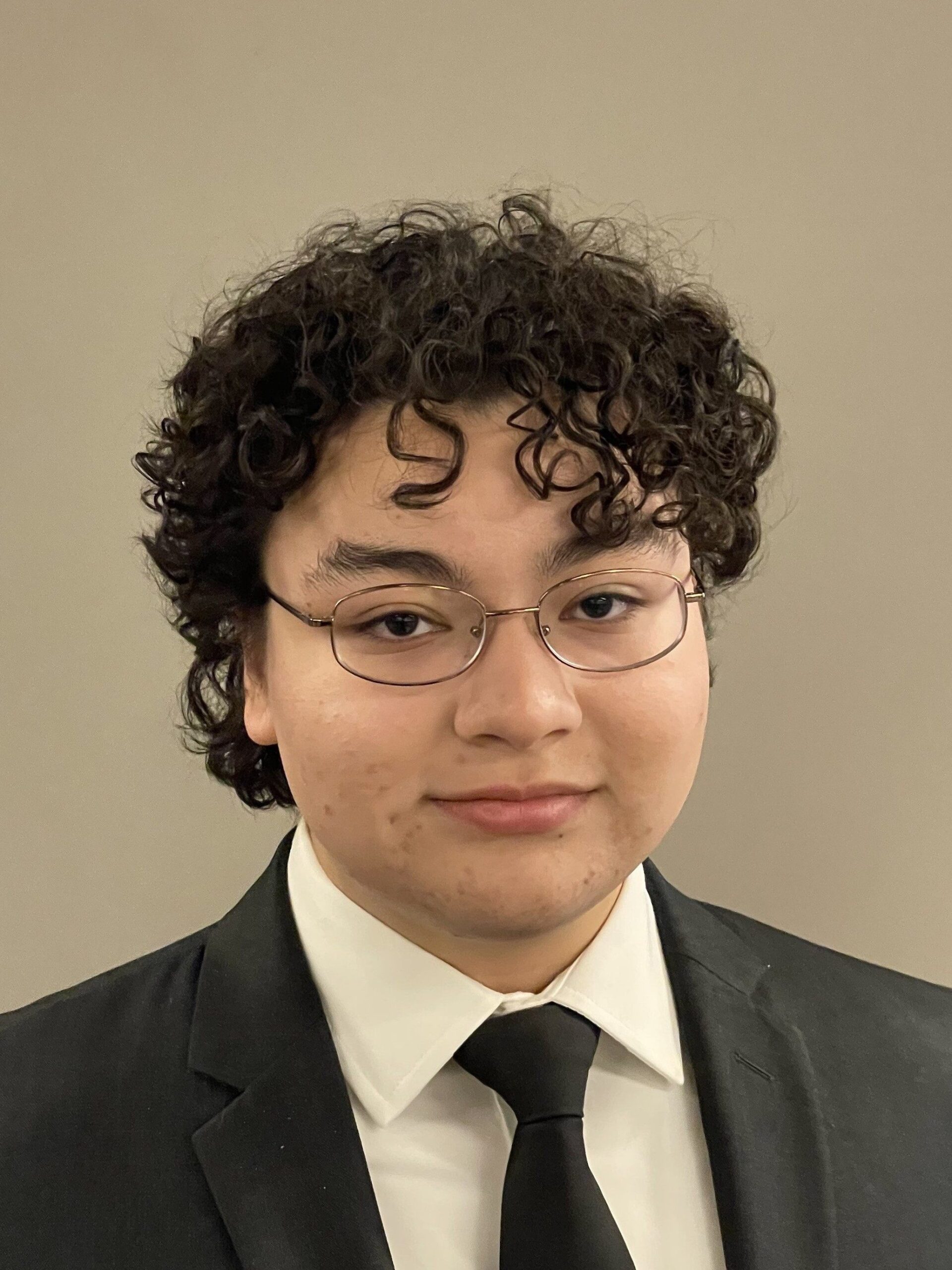 Sonny Lopez is posed for a headshot, dressed in professional attire.